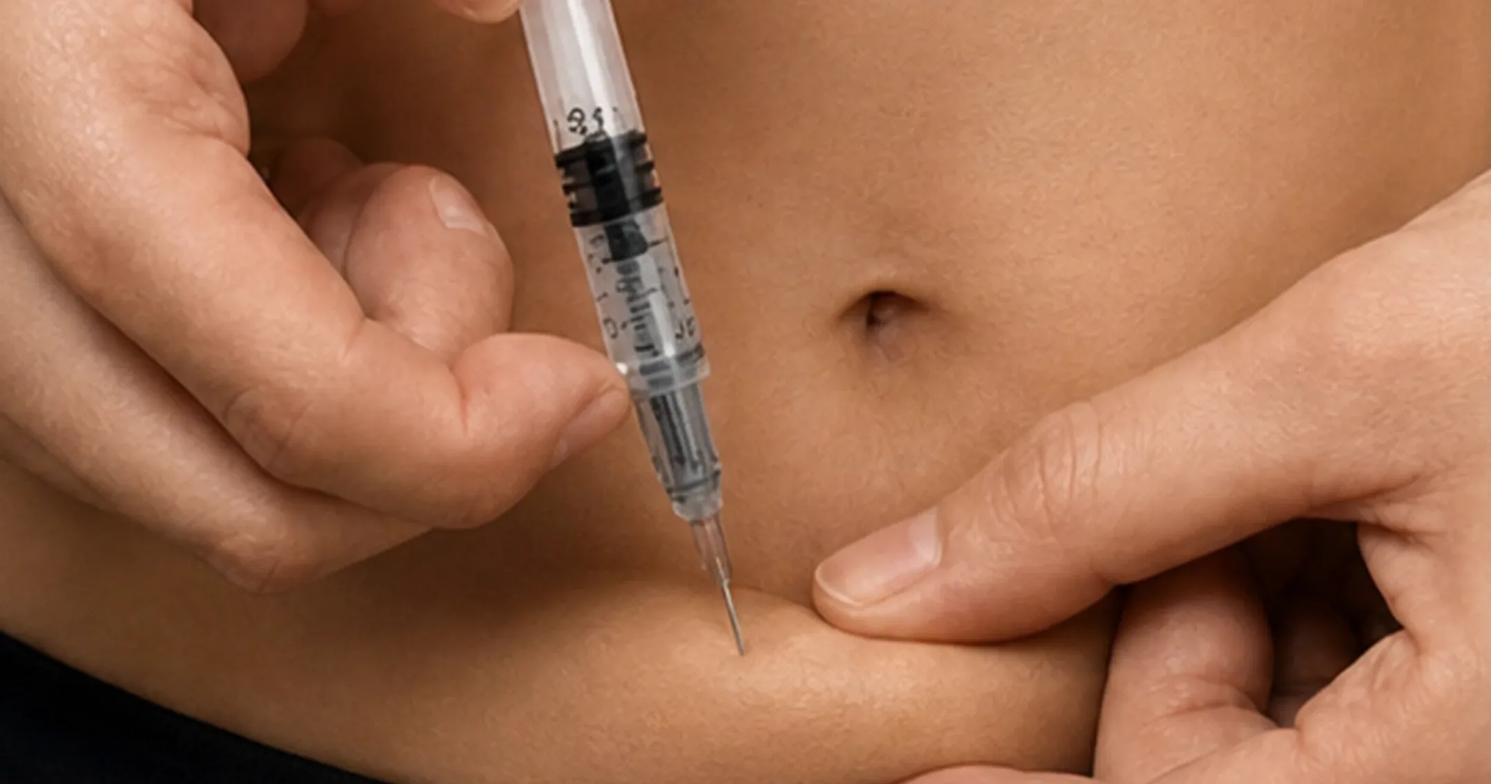 Jeringa de insulina administrando lentamente en pliegue abdominal